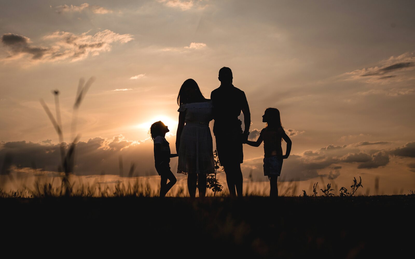 Absicherung: Familie zusammen bei Sonnenuntergang